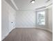 Bright bedroom featuring a white patterned accent wall, neutral walls, and wood floors at 4436 Hosch Reserve Ct, Buford, GA 30519