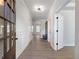 Long hallway with white walls, wood floors, and a view into the main living area at 4436 Hosch Reserve Ct, Buford, GA 30519