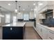 Bright kitchen features white cabinetry, a navy island, stainless appliances, and pendant lighting at 4436 Hosch Reserve Ct, Buford, GA 30519