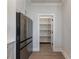 Well-organized pantry with custom white shelving, adjacent to a stainless steel refrigerator at 4436 Hosch Reserve Ct, Buford, GA 30519