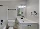 Well-lit bathroom featuring a modern sink, toilet, and tub with bright, white tile at 1102 Tony Valley Dr, Conyers, GA 30013