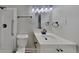 Bright bathroom featuring a modern sink, toilet, and shower with white tile and black matte fixtures at 1102 Tony Valley Dr, Conyers, GA 30013