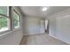 Neutrally decorated bedroom featuring large windows, carpet, and access to a hallway at 1102 Tony Valley Dr, Conyers, GA 30013