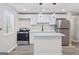 Modern kitchen featuring white cabinets, stainless steel appliances, and stylish pendant lighting at 2106 Singer Way, Lithonia, GA 30058