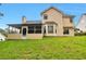Back view of home with a screened-in porch overlooking the grassy backyard at 2428 Harmony Ridge Ct, Lithonia, GA 30058