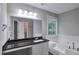 This bathroom boasts granite counters, a jetted tub, and large mirror at 2428 Harmony Ridge Ct, Lithonia, GA 30058
