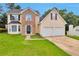 Charming two-story home featuring a two-car garage, stone accents, and a well-manicured lawn at 2428 Harmony Ridge Ct, Lithonia, GA 30058