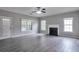 Spacious living room featuring a black fireplace, ceiling fan, and lots of natural light at 2428 Harmony Ridge Ct, Lithonia, GA 30058