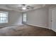 A spacious main bedroom boasting multiple windows, a tray ceiling, carpet floors, and a ceiling fan at 2428 Harmony Ridge Ct, Lithonia, GA 30058