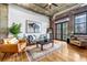 Bright living room features hardwood floors, exposed brick, and an open layout leading to outdoor access at 3180 Mathieson Drive # 703, Atlanta, GA 30305
