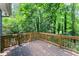 Wooden deck with railings surrounded by lush trees and greenery, perfect for outdoor relaxation at 4990 Turtle Rock Drive Dr, Marietta, GA 30066
