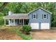 Inviting blue home with a covered front porch, two-car garage, and well-maintained landscaping at 4990 Turtle Rock Drive Dr, Marietta, GA 30066