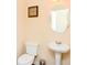 Well-lit half bathroom with a pedestal sink, framed mirror, and toilet at 2010 Shortleaf Rd, Fairburn, GA 30213