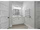 Bright bathroom featuring a white vanity with large mirror and modern lighting fixture at 4445 Pebble Rock Dr, Cumming, GA 30041
