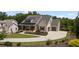 Beautiful home with a landscaped lawn, covered porch, attached garage, and a large driveway at 4445 Pebble Rock Dr, Cumming, GA 30041