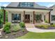 Inviting front porch with natural wood columns, outdoor seating and manicured landscaping at 4445 Pebble Rock Dr, Cumming, GA 30041