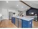 Open-concept kitchen with a blue island, stainless appliances, and a view to the living area at 4445 Pebble Rock Dr, Cumming, GA 30041