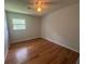 A vacant bedroom features hardwood floors, a ceiling fan, and a window at 713 Pine Chase Ct, Lawrenceville, GA 30043