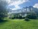 Traditional two-story home with a lush green lawn and mature trees providing shade at 713 Pine Chase Ct, Lawrenceville, GA 30043