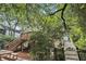 Exterior of the home with upper deck, brick patio, and stairway surrounded by lush greenery and trees at 1718 Ridgewood Ne Dr, Atlanta, GA 30307
