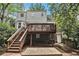 Exterior view of the home showing an upper deck, lower patio and mature trees at 1718 Ridgewood Ne Dr, Atlanta, GA 30307