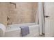 Bathroom with travertine tile, white tub and shower combination, and a white door at 1718 Ridgewood Ne Dr, Atlanta, GA 30307
