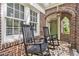 Charming brick front porch with rocking chairs, tile floor and arched entryway at 1718 Ridgewood Ne Dr, Atlanta, GA 30307