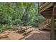 Brick patio with dining table, benches, chairs and stairs to the deck, nestled in a lush backyard at 1718 Ridgewood Ne Dr, Atlanta, GA 30307
