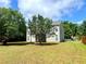 The backyard has green grass and trees, offering plenty of space for outdoor activities and relaxation at 203 Galway Ln, Hampton, GA 30228
