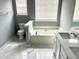 Bathroom with soaking tub, granite counters, dual sinks and tile floor at 203 Galway Ln, Hampton, GA 30228