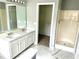 Bathroom featuring dual sinks, walk-in shower, and modern finishes at 203 Galway Ln, Hampton, GA 30228