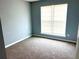 A simple bedroom features neutral carpet, paint, and a window at 203 Galway Ln, Hampton, GA 30228