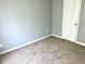 This bedroom features neutral paint, carpet, and a white door at 203 Galway Ln, Hampton, GA 30228