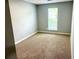 This bedroom features neutral paint, carpet, and a window at 203 Galway Ln, Hampton, GA 30228