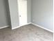 This bedroom features neutral paint, carpet, and a white door at 203 Galway Ln, Hampton, GA 30228