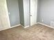 This bedroom features neutral paint, carpet, and a white door at 203 Galway Ln, Hampton, GA 30228