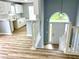 Inviting entryway features wood floors, staircase, and view of kitchen with white cabinets at 203 Galway Ln, Hampton, GA 30228