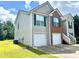 Side view of a two-story home featuring a two-car garage and vinyl siding, on a sunny day at 203 Galway Ln, Hampton, GA 30228