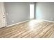 Open living room featuring laminate wood flooring, neutral paint, and lots of sunlight at 203 Galway Ln, Hampton, GA 30228