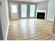 Bright living room features fireplace, wood floors, and natural light from windows at 203 Galway Ln, Hampton, GA 30228