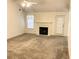 Open living room featuring neutral carpet, a ceiling fan, and a fireplace at 3041 Regal Dr, Mcdonough, GA 30253