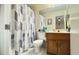 Functional bathroom features a vanity with a sink and a toilet behind a patterned shower curtain at 5359 Stafford Nw Dr, Lilburn, GA 30047