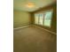 This bedroom features neutral carpet, a large window with lots of natural light, and light olive walls at 2895 Brandl Cove Ct # 4, Marietta, GA 30067