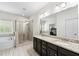 Bright bathroom featuring double vanity with granite countertop, tub, and glass shower at 510 Black Horse Cir, Canton, GA 30114