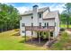 Rear exterior view of a two-story home featuring a spacious deck, well-manicured lawn, and a walkout basement entrance at 510 Black Horse Cir, Canton, GA 30114