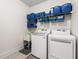 Well-lit laundry room featuring a sink, washer, dryer, and ample shelving for storage at 510 Black Horse Cir, Canton, GA 30114