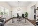 Bright home office with large window, chandelier, and modern desk setup near the foyer and kitchen at 510 Black Horse Cir, Canton, GA 30114