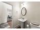 Well-lit powder room featuring a pedestal sink, decorative mirror and a view into the nearby office at 510 Black Horse Cir, Canton, GA 30114