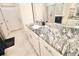 Modern bathroom vanity with granite countertops, white cabinets, and a decorative mirror at 605 Oak Ln, Canton, GA 30114