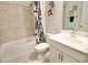Well-lit bathroom featuring a shower-tub combination, decorative flower accents, and a modern vanity at 605 Oak Ln, Canton, GA 30114